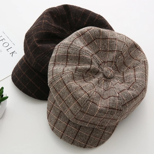 Detail showing vintage plaid and solid brown wool textures of the octagonal newsboy caps
