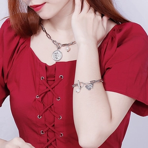 Silver titanium steel jewelry set with angel coin and pearl pendant on a red background