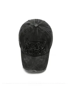 Close-up of distressed denim baseball cap featuring New York patch with frayed edges