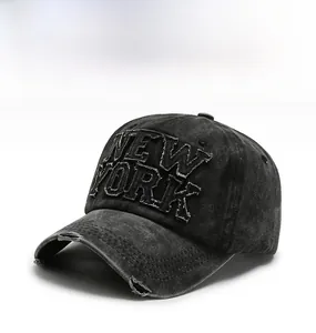 Detail view of distressed washed denim baseball cap with New York patch embroidery