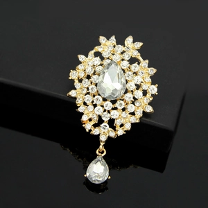 Detailed view of a golden crystal flower brooch with shimmering teardrop pendant drops