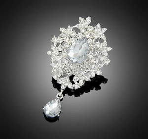 Macro shot of a vintage silver brooch with clear crystals and a teardrop pendant detail