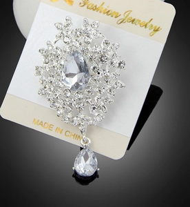 Detailed view of flower brooch with crystal petals and pear-shaped drop pendant