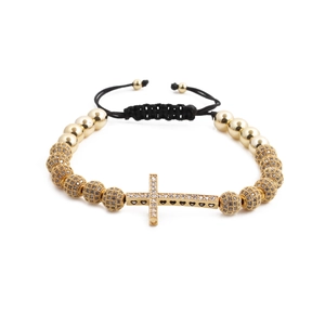 Detailed macro view of a cross pendant with micro-pave zircons and golden metal beads