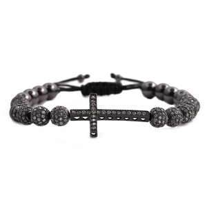 Close-up of black beaded bracelet with micro-paved cross pendant and adjustable woven cord