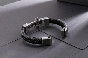 Close-up of black braided leather bracelet featuring vintage industrial metal magnetic clasp