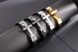 Detail of cross braided leather bracelets in four colors on cylindrical stands