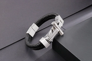 Detail view of black woven leather strap and silver stainless steel clasp on male bracelet