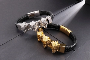 Dettaglio dei ciondoli a testa di lupo e della pelle intrecciata su un bracciale punk