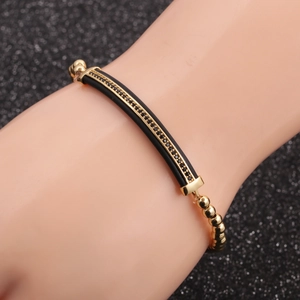 Macro detail of men's crown bracelet set with black micro-inlaid stones on gold beads