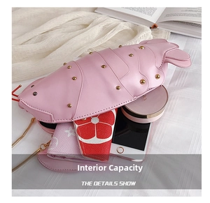 Internal capacity of lobster-shaped pink bag showing phone and essentials storage