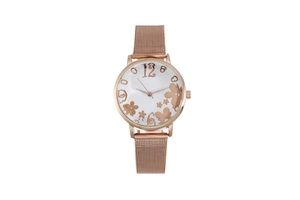 Detailed close-up of rose gold mesh band watch with white floral art dial