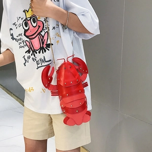 Detailed close-up of a creative red lobster shaped crossbody bag with gold chain strap