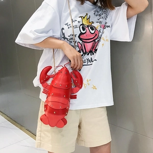 Creative red lobster shaped crossbody bag with metallic chain strap worn by a model