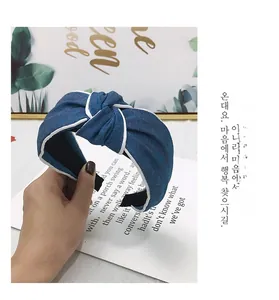 Detail showing blue denim wide headband with white piping and top knotted design