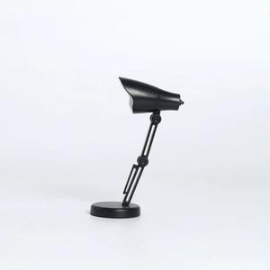 Vue détaillée de la mini lampe de bureau LED pliable en noir montrant les bras articulés