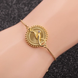 Detail of adjustable gold snake pendant bracelet with sparkling central zircon on wrist