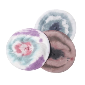 Primo piano dettagliato che mostra tre berretti in lana tie-dye nei toni blu, viola e marrone