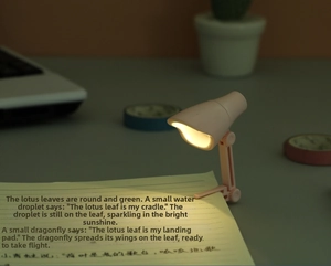 Mini lampe de lecture LED rose avec clip sur carnet diffusant une lumière chaude