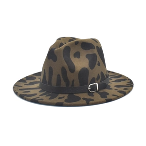 Dettaglio del cappello in feltro con motivo mucca e cinturino in pelle nera con fibbia
