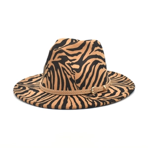 Close-up of zebra pattern fedora hat with brown leather band and gold buckle detail