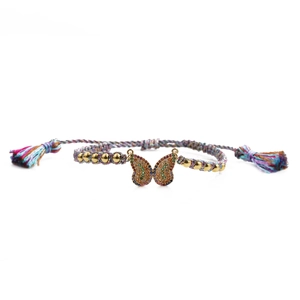 Colorful woven butterfly bracelet with gold zircon-studded charm on white background