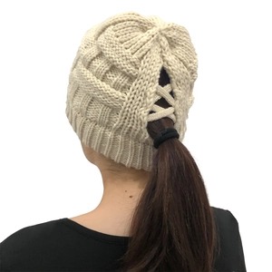Detail of cross-strap ponytail opening on beige ribbed knit beanie for long hair