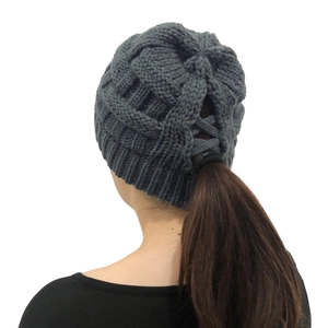 Detail view of the ponytail hole opening on a grey striped knit beanie for women