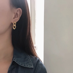 Minimalist double chain link earrings in 18K gold plated steel on a model's ear
