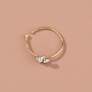 Close-up of gold nose ring featuring three sparkling rhinestones in a plum flower shape