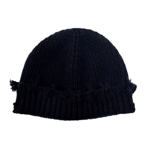 Détail d'un bonnet en maille gaufrée noire avec bords effilochés au style vintage streetwear