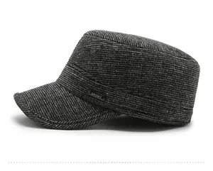 Detail view of dark grey tweed flat cap with a metallic Sport emblem and side texture