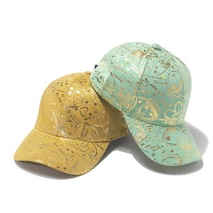 Detail of fashion baseball caps in yellow and mint green with gold graffiti prints