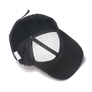 Detail of 100% cotton baseball cap interior with white mesh support and metal buckle