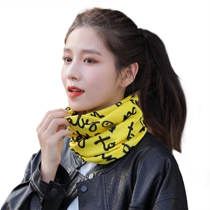 Yellow knitted neck gaiter with black graffiti print worn with a black leather jacket