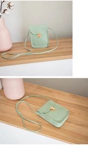 Detail view of light green crocodile pattern PU leather phone bag with gold metal clasp