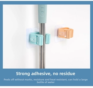 Adhesive mop holder with non-slip rollers showing strong grip on a metal handle