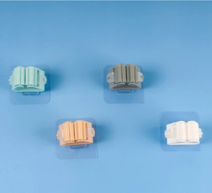 Wall-mounted mop holders in four colors with adhesive base on blue background