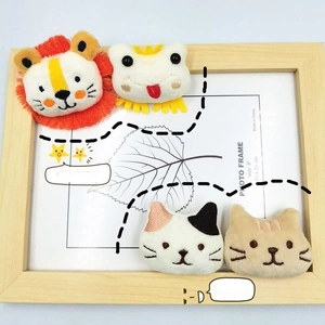Detailed close-up of cute plush animal brooches featuring lion, frog and kitten designs
