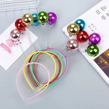 Détail de serre-têtes à ressort colorés avec boules métalliques brillantes pour filles