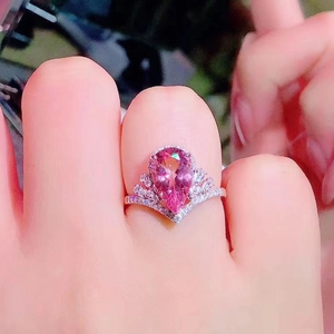 Detailed macro shot of a pear-cut pink stone set in a luxury silver crown ring band