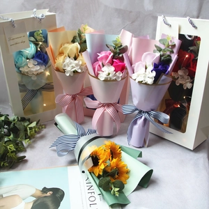 Detail of assorted soap flower bouquets in gift bags with ribbons and window boxes