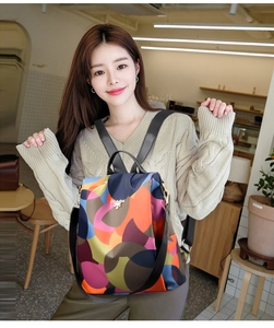 Detailed view of the multi-color geometric nylon backpack with golden logo and straps