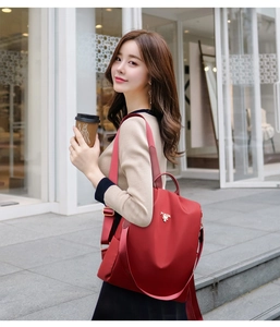 Modern red nylon backpack for women with metal zipper and stylish decorative buckle detail