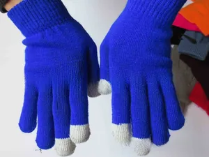 Close-up of blue winter knit touchscreen gloves with grey conductive fingertips and ribbed cuffs