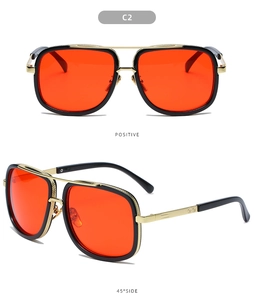 Detail of red lenses and double bridge design on black and gold pilot sunglasses