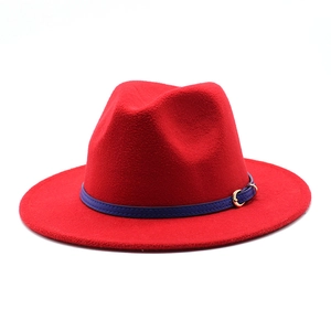 Detail of red wool fedora hat with blue decorative leather strap and golden metal buckle