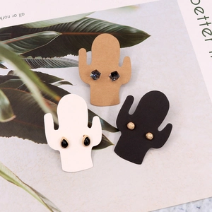 Three pairs of earrings displayed on cactus-shaped jewelry cards in black, white, and brown