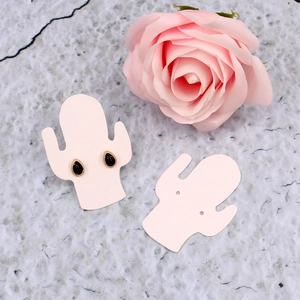 Pink cactus jewelry display cards with gold stud earrings and floral background accent