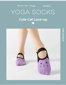 Detail of purple yoga socks with cute cat face print and elastic cross straps